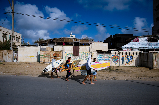 Gaza, surfers Yosef Abu Ghanem (second from left), Mahmoud Osama Al-Rayashi  (third from left) and other two friends walk to the beach.