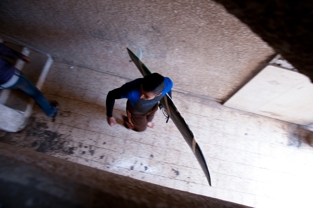 Gaza, Mahmoud Osama Al-Rayashi leaves his house carrying a surfboard