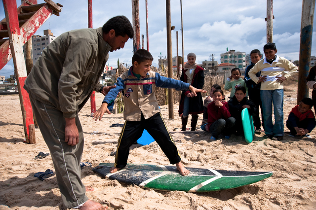 Gaza, Al Hindi Ashour gives surfing lessons to youngsters on the beach