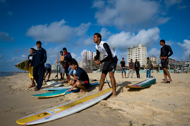 Gaza, Mahmoud Osama Al-Rayashi (center) and other friends preparing for surf.