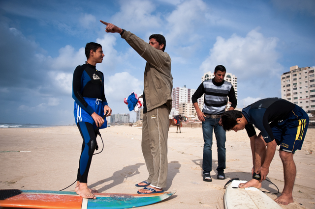 Gaza, Al Hindi Ashour speaks with young Yosef Abu Ghanem before entering the water