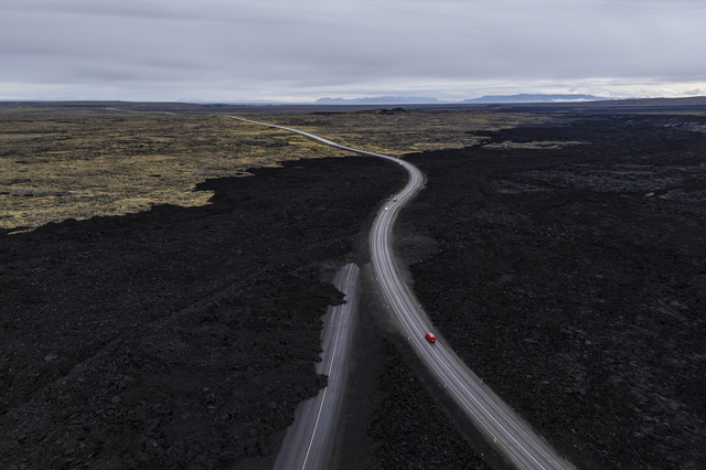 Grindavik (Iceland): a few cars are driving along the road linking the village to the Blue Lagoon area. The road on the left, which is closed, has been covered by lava that flowed as a result of volcanic activity, which led to nine eruptions between December 2023 and August 2025: Iceland’s landscape is changing extremely rapidly, even from a geological perspective.