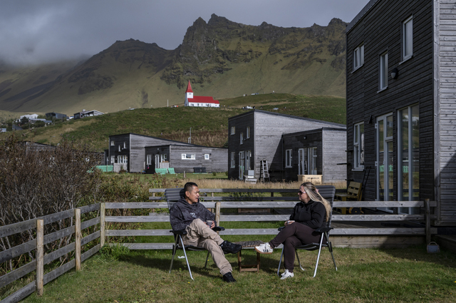 Vik (Iceland): Delfin Dimailig, a 41-year-old Filipino, inspects a piece of lava rock that is due to go on sale at the Lava Show. Delfin used to work on cruise ships and, eight years ago, he moved to Iceland with his wife Dominika, a Polish woman (on the right, in their garden), whom he met on board. Today, in the village of Vik (where 68 per cent of the inhabitants are of foreign origin), as well as working with stone, he is also the only barber: “I learnt on the ships… here, people used to cut their own hair!”